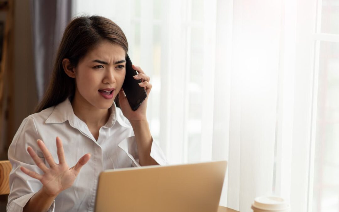 A woman on a stressful phone call with a bad property manager.