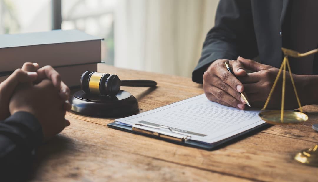 two people signing a legal agreement