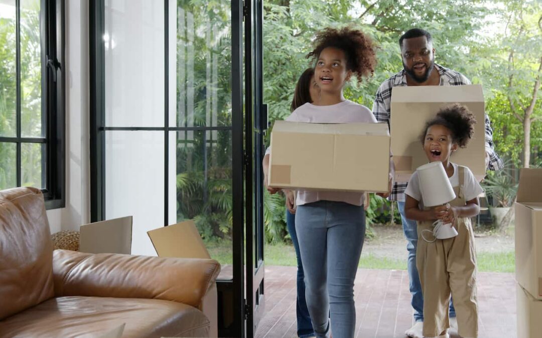 a family carrying boxes preparing to move out of their rental home